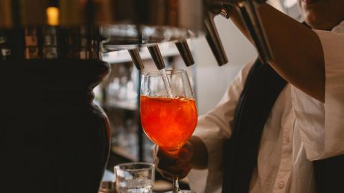 a person holding a wine glass in a bar at Hotel Restaurant Taverna in Eching