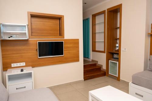 a living room with a television on a wall at Holiday Village Türkiye in Dalaman
