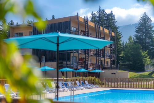 Cet hôtel possède une piscine avec des chaises et un parasol. dans l'établissement Résidence Goélia Le Sornin, à Autrans