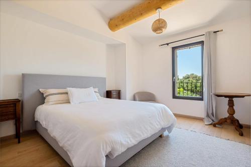 une chambre blanche avec un lit et une fenêtre dans l'établissement Villa Horizon, à Eygalières
