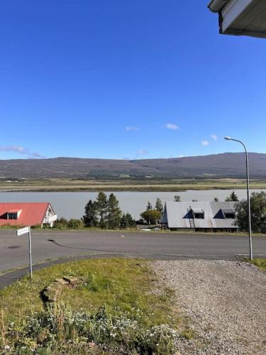 a street light next to a road with houses and a lake at Lakeside Apartments - A in Egilsstadir