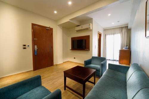 a living room with a couch and chairs and a table at Stay Inn Cairo Hotel in Cairo