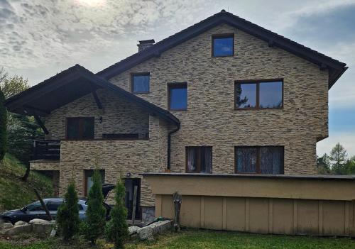 a house with a car parked in front of it at Wellness Toliar Tatry in Stará Lesná