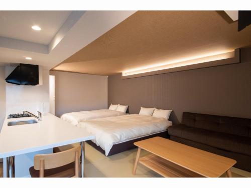 a small room with a bed and a table at Stay's OTARU in Otaru