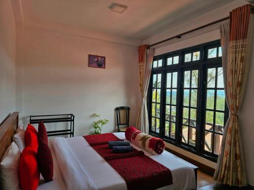 a bedroom with a bed and a large window at Chez Allen in Nuwara Eliya