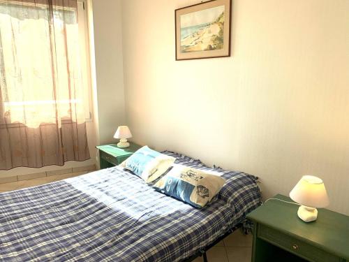 - une chambre avec un lit et 2 tables vertes dans l'établissement Appartement avec WIFI VUE SUR MER plage du Coz-Pors à TREGASTEL - Réf 609, à Trégastel