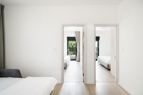 a bedroom with two beds and two mirrors at Adama by Sweett - Keren Hayesod Apartments in Jerusalem