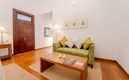a living room with a green couch and a coffee table at Lotus Estate Colombo in Colombo