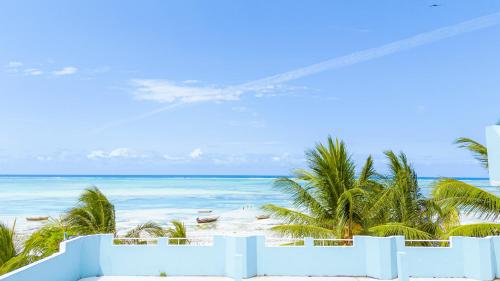 a view of a beach with palm trees and the ocean at Sands Inn Hotel in Pwani Mchangani