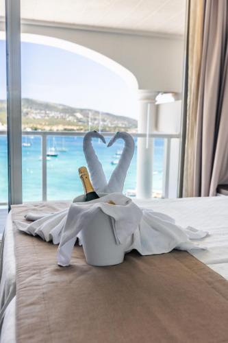 a hotel room with a bed with two swans forming a heart at Seramar Hotel Comodoro Playa in Palmanova