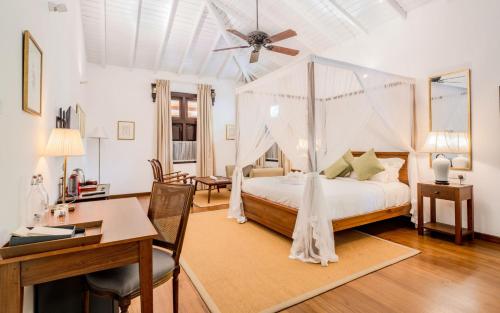 a bedroom with a bed with a ceiling fan at Lotus Estate Colombo in Colombo