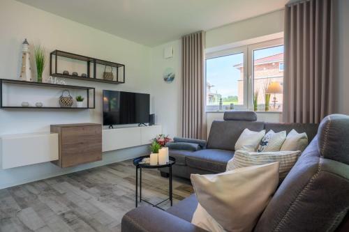a living room with a couch and a tv at Fewo Lüttje Parl in Hooksiel