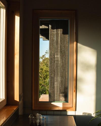 a window in a kitchen with a view of a building at Veritas Beyond Glamping in Hošťka