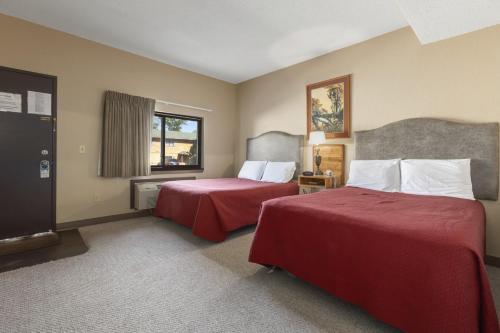 a hotel room with two beds and a window at Commander Motel in Pequot Lakes
