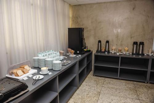 a table with plates and cups on top of it at Ville Celestine Hotel in Belo Horizonte