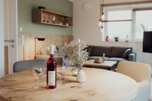 a bottle of wine sitting on a table with wine glasses at Fewo Graureiher Obergeschoss in Hooksiel