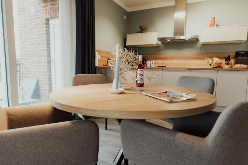 a kitchen and dining room with a wooden table and chairs at Fewo Graureiher Obergeschoss in Hooksiel