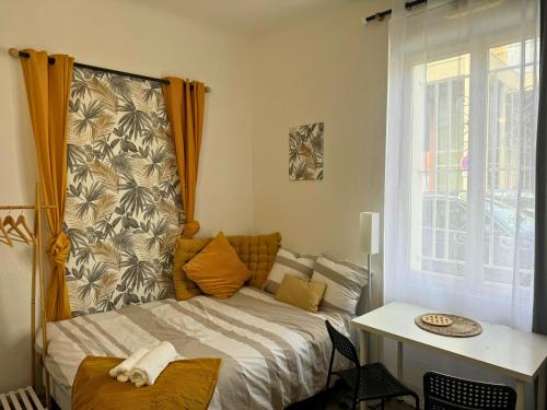 une chambre avec un lit, une table et une fenêtre dans l'établissement Mini Nid - Centre - Wifi - Equipé - Cosy, à Dax