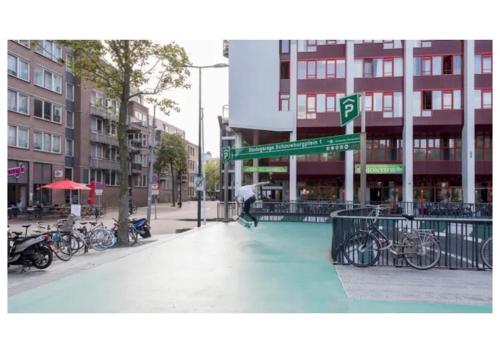 a person riding a skateboard in the middle of a street at OHotellMe City Apartments Rotterdam in Rotterdam