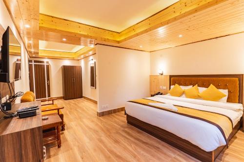 a bedroom with a large bed and a television at The Golden Retreat Hotel in Pelling in Pelling