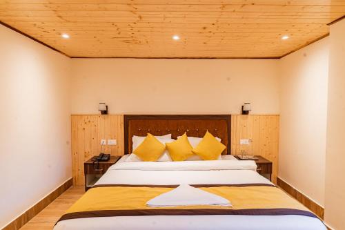 a bedroom with a large bed with yellow pillows at The Golden Retreat Hotel in Pelling in Pelling