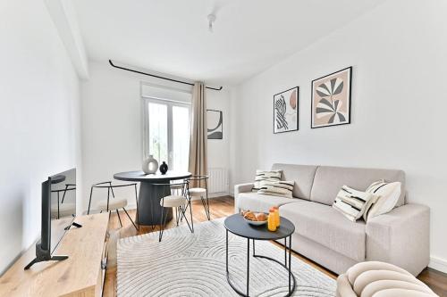 un salon avec un canapé et une table dans l'établissement Appartement à Montreuil cosy et confortable - II, à Montreuil