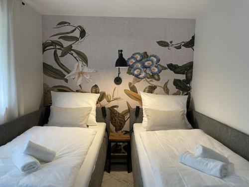 two beds in a room with a floral wall at Grafschafft angenehmes wohnen - Ferienwohnung mit 2 Schlafzimmern in Pirna