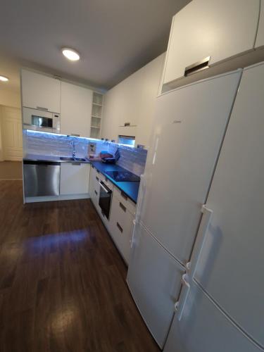 a large kitchen with white appliances and wooden floors at Pajala Centralt 19B in Pajala