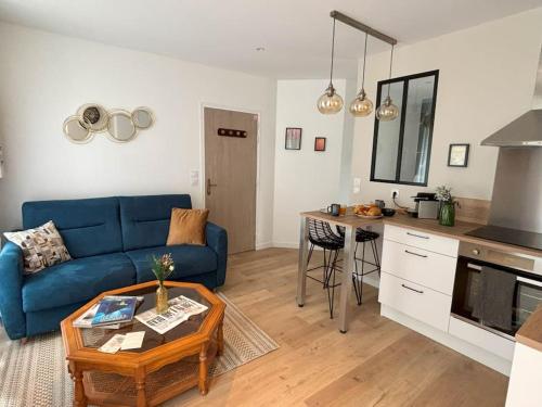un salon avec un canapé bleu et une table dans l'établissement Studio Titanic Cherbourg Netflix Parking, à Cherbourg en Cotentin