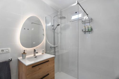 a bathroom with a sink and a shower with a mirror at El Rinconcito De Niña in Tijoco de Abajo