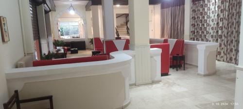 a salon with red chairs and a waiting room at PANTHEON HALL HOTEL in Mesongi