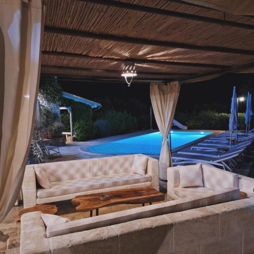 a living room with couches and a swimming pool at Villa Belvedere in Ostuni