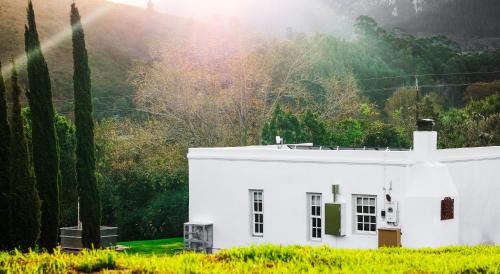 a white house with a hill in the background at The Hamlet in Swellendam
