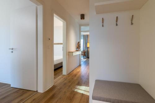 a bedroom with white walls and a door leading to a hallway at Fewo Sonne und Meer in Hooksiel