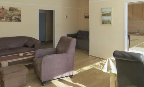 una sala de estar con un sofá y una silla en Ferienwohnung Klabautermann, en Hooksiel