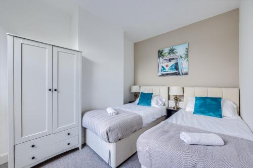 a bedroom with two beds and a dresser at Charming House in Prime Location - Sleeps 7 - Free Parking, Fast WiFi, Smart TV with Netflix and Virgin TV by Yoko Property in Northampton