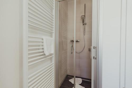 a shower with a glass door in a bathroom at Fewo Alk Obergeschoss in Hooksiel