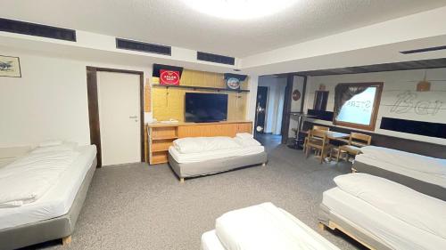 a room with two beds and a desk with a television at Sternen B&B & Italienisches Restaurant in Elm