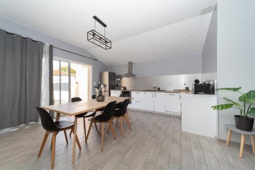 a kitchen and dining room with a wooden table and chairs at Gîte Chelona d'Hermann - parking - Chelona'Loc in Braud-et-Saint-Louis