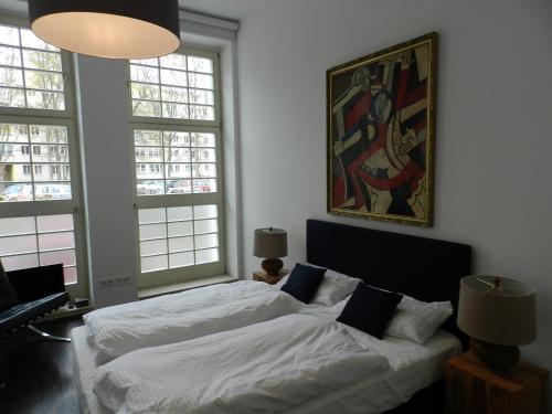 萊比錫的住宿－萊比錫裝飾藝術公寓，一间卧室设有两张床,墙上挂着一幅画