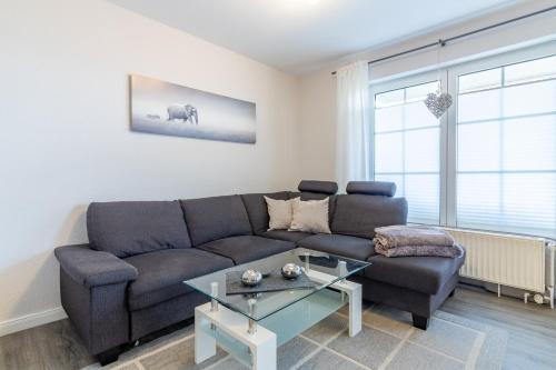 a living room with a couch and a table at Ferienwohnung Ebbe in Hooksiel