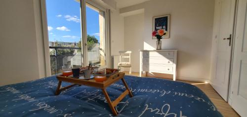 Cette chambre comprend un lit avec une table. dans l'établissement Le Clemenceau appart-Calais Nord-balcon-plage, à Calais