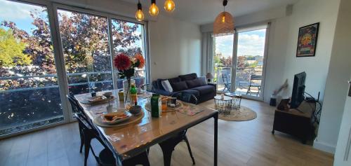 un salon avec une table et un canapé dans l'établissement Le Clemenceau appart-Calais Nord-balcon-plage, à Calais