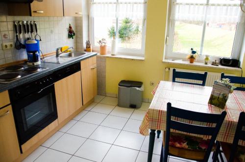 a kitchen with a table and a sink and a stove at Ferienwohnung Janto in Hooksiel