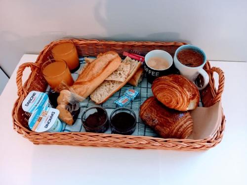 a basket of bread and pastries and two cups of coffee at Location calme in Cournon-dʼAuvergne