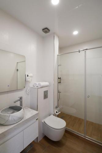 a bathroom with a toilet and a glass shower at Hotel & Restaurant Emerald Borjomi in Borjomi
