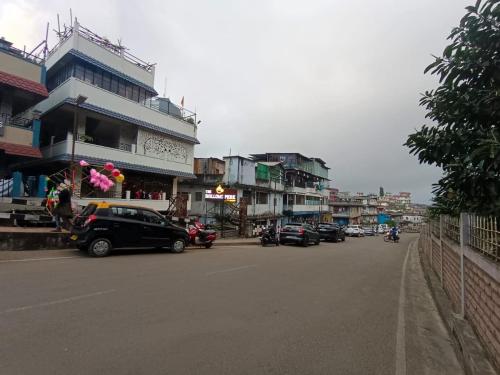 a city street with cars parked in front of buildings at Cental Homestay in Shillong