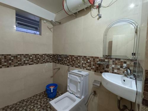 a bathroom with a sink and a toilet and a mirror at Cental Homestay in Shillong