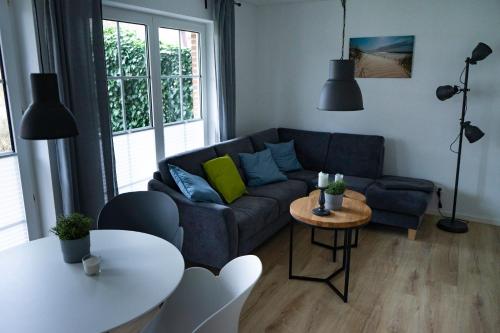 a living room with a blue couch and a table at Ferienwohnung Wassmann Hooksiel in Hooksiel
