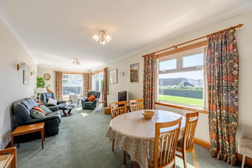 a living room with a table and chairs at Anthony House in Kippford